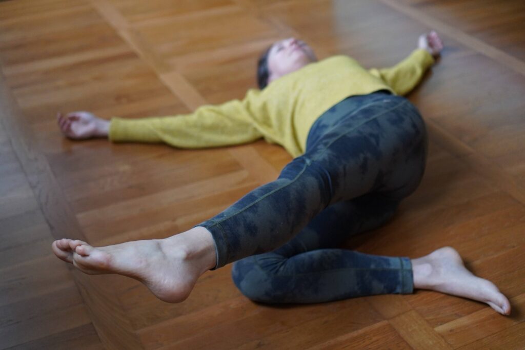 Personne allongée sur un tapis pendant un cours MUNZ FLOOR en ligne