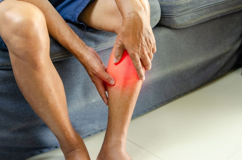 Joueur de football tenant son mollet après une douleur musculaire soudaine