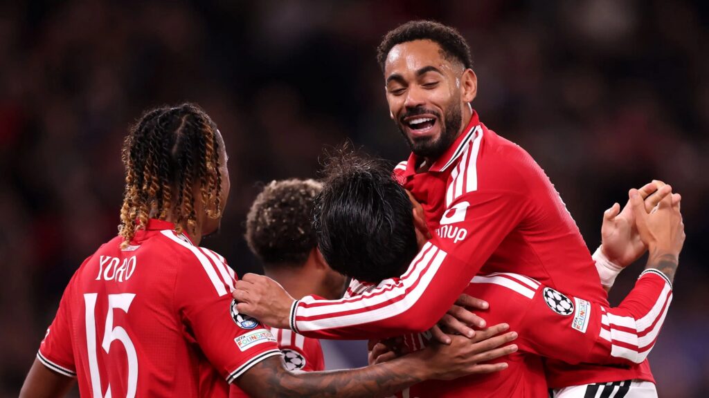 Joueurs de Manchester United en maillot rouge sur la pelouse d'Old Trafford