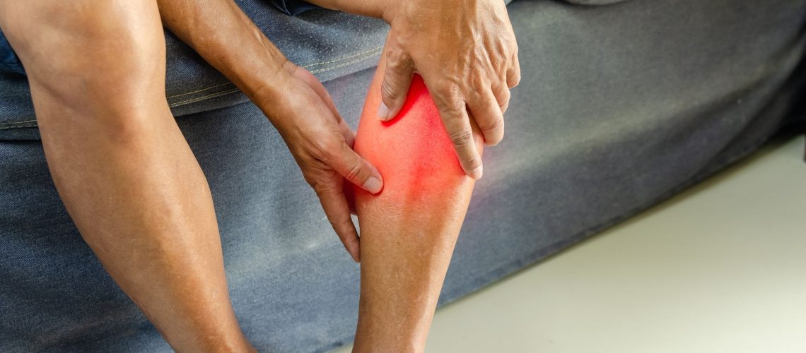 Joueur de football tenant son mollet après une douleur musculaire soudaine